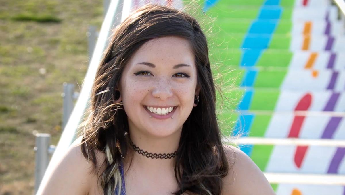 ODU alumni Aimee Bruce smiles in front of painted stairs.