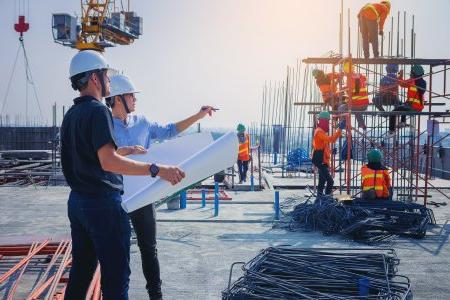 结构工程师和建筑师在室外施工现场讨论图纸